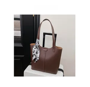 Detail of dark brown tote bag with lychee texture and decorative floral silk scarf
