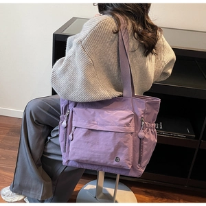Detailansicht lila wasserdichte Nylon-Einkaufstasche mit Taschen und Metalllogo