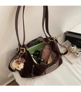 Vue détaillée de l'intérieur du grand sac fourre-tout en daim avec charme d'ours et accessoires