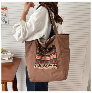 Detailed view of brown tote bag with colorful ethnic pattern faux fur pocket on model