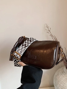 Retro dark brown cylinder pillow bag with geometric wide strap for casual crossbody wear