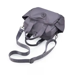 Top view of a grey waterproof nylon tote bag showing zipper pockets and woven logo strap