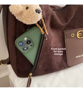 Détail du sac cabas en daim avec poche latérale zippée et boucle métallique sur le devant