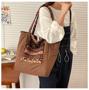 Detail of large brown tote bag with ethnic pattern fleece pocket and cozy textures