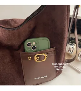 Détail de la poche avant en daim avec boucle métallique et rangement pour téléphone