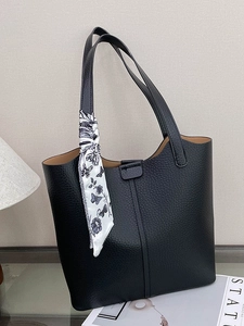 Minimalist black lychee leather tote bag with floral silk scarf on shoulder strap