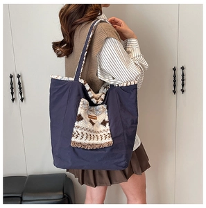 Detail of navy tote bag with white faux shearling trim and ethnic woven pocket detail