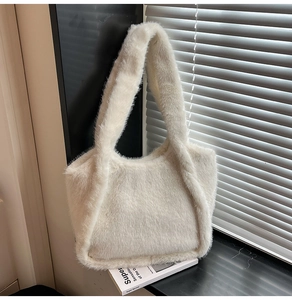 Detail of soft white faux fur tote bag showing plush texture and integrated handle design