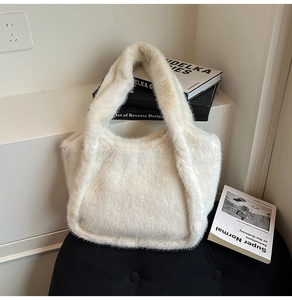 Detail of white plush faux fur tote bag with soft texture and wide shoulder strap