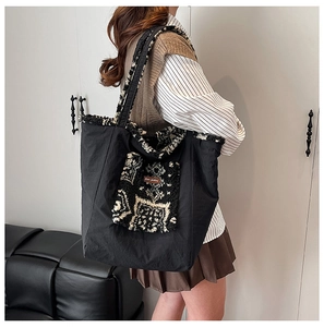 Detail view of ethnic style tote bag with contrast lamb wool pocket and shoulder strap