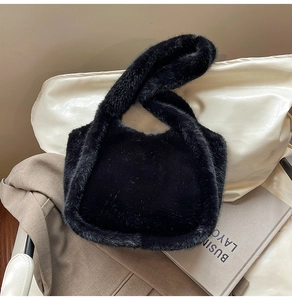 Close-up of fluffy black faux fur tote bag showing soft fiber texture and wide handle