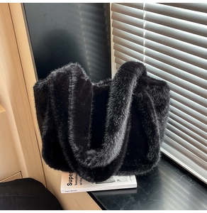 Detail of soft black faux fur tote bag showing plush texture and wide double handles