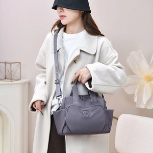 Detail of gray nylon crossbody bag with adjustable wide logo strap and side pockets
