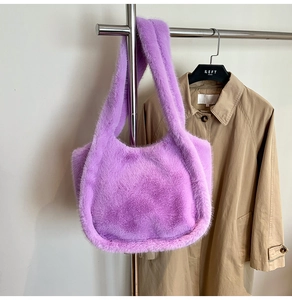 Detail of plush lavender purple faux fur tote bag hanging on a minimalist display stand