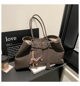 Detail einer braunen Vintage-Leder-Tote Bag mit süßem Dackel-Taschenanhänger