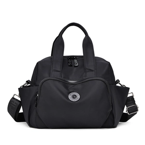 Front detail of black waterproof nylon handbag showing zippers and large pockets