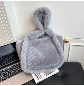 Close-up of fluffy grey faux fur tote bag showing plush texture and stylish top handle