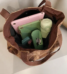 Spacious interior of plaid tote bag showing tablet, water bottle and everyday essentials
