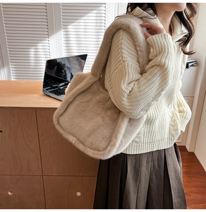 Detail of plush beige shoulder bag showing the fuzzy faux fur texture and wide strap