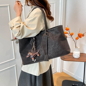 Retro Holzkohle-Shopper mit Hundeanhänger und Quaste in minimalistischer Wohnumgebung