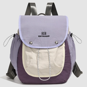 Detail of the water-resistant nylon fabric and logo on the purple trekking backpack
