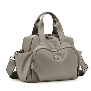Detail view of water-resistant nylon handbag with adjustable strap and multiple pockets
