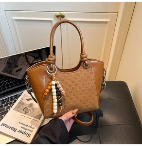 Détail du sac seau en cuir marron avec gaufrage à carreaux et perles en bois colorées