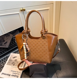 Détail du sac seau en cuir caramel avec gaufrage en damier et perles en bois colorées