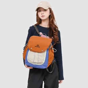 Detail of multi-color hiking backpack with drawstrings and buckle closure on gray backdrop