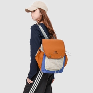 Detail of multi-color hiking backpack with drawstring closure and metal button accents