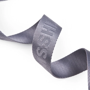 Macro shot of high-density grey woven strap with jacquard lettering and silk luster