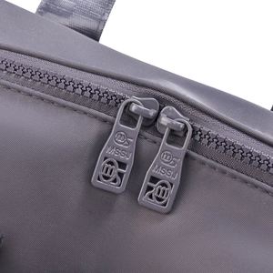 Detail of high-density nylon bag showing dual metal zippers with engraved MSSJ logo