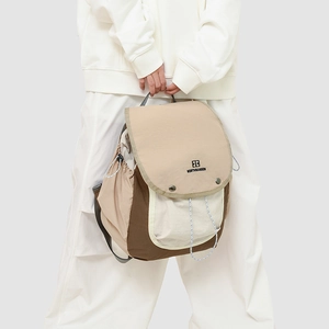 Outdoor leisure backpack with multi-color splicing and buckle closure on a female model