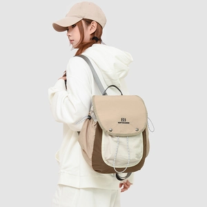 Detail of multi-color hiking backpack with brand logo shown from a side-view on a model
