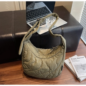 Vue détaillée du sac croissant matelassé vert olive avec étiquette de marque urbaine