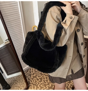 Close-up of large black faux fur tote bag showing the rich texture and wide shoulder strap