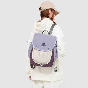 Detail of multi-color hiking backpack showing the buckle closure and flap logo