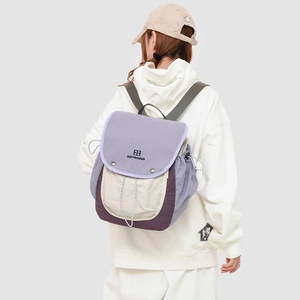 Detail of waterproof nylon patchwork backpack with flap closure and side drawstring pockets
