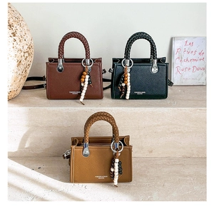 Detailansicht der kleinen quadratischen Taschen aus Litschileder mit gewebten Griffen