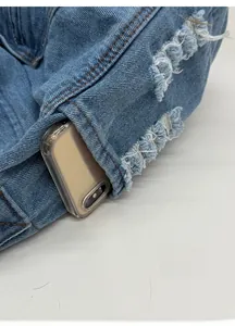 Detail of cargo-style denim bag with a large functional side pocket and distressed finish