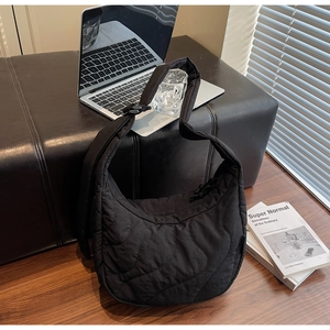 Vue détaillée du sac hobo noir matelassé avec surpiqûres vagues et bandoulière