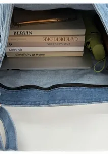 Interior view of denim tote bag showing large capacity for laptop, books, and umbrella