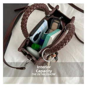 Innenkapazität der braunen Vintage-Handtasche mit Handy und Kosmetikartikeln