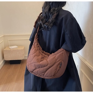 Détail du sac à bandoulière matelassé marron en forme de croissant avec surpiqûres