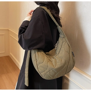 Vue latérale du sac bandoulière matelassé vert olive avec motifs de coutures ondulées