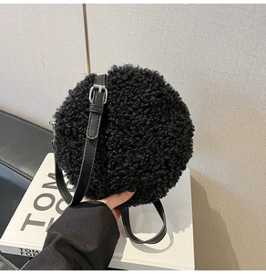 Close-up of black fluffy faux lamb wool round shoulder bag with adjustable leather strap