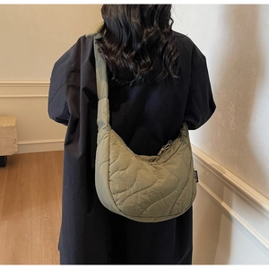 Vue arrière d'un sac hobo matelassé vert sauge avec coutures ondulées sur modèle