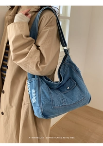 Close-up of blue denim hobo bag featuring utility pockets and distressed edge details