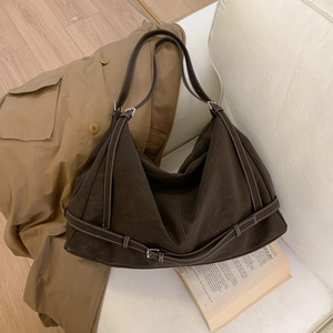 Detailed close-up of dark brown vintage tote with white stitching and metal buckle