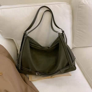 Detail of dark olive green hobo bag featuring matte PU leather and decorative metal buckles